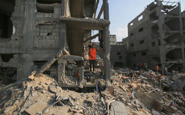 Palestyńczycy sprawdzają zniszczenia po izraelskim ataku na obóz dla uchodźców w Strefie Gazy