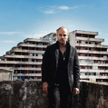 Ciro Di Marzio (Marco D'Amore) na tle ponurego wieżowca Vele di Scampia