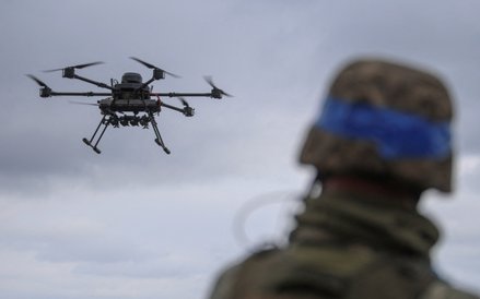 Ukraiński żołnierz przyglądający się ciężkiemu dronowi Wampir niedaleko linii frontu w obwodzie doni