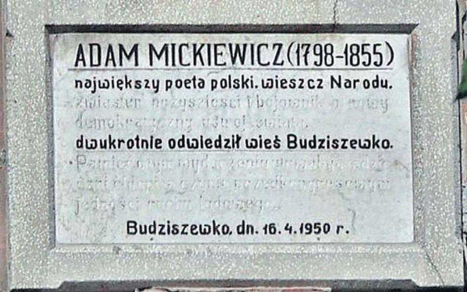 Budziszewko, na tablicy niewidoczny tekst z lat 50.: „...Zwiastun przyszłości bojownik o nowy demokr