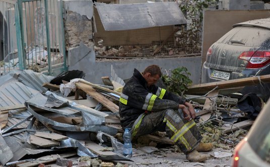 Ratownik siedzi wśród gruzów we Lwowie po ataku na miasto