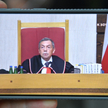 Sędzia Trybunału Konstytucyjnego Bartłomiej Sochański podczas obrad oglądanych na ekranie telefonu p