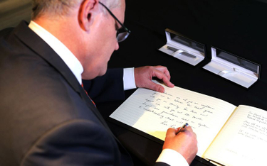 Premier Australii Scott Morrison wpisuje się do księgi kondolencyjnej po ataku w Christchurch