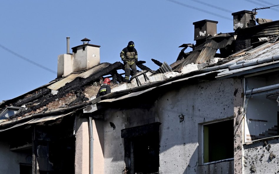 Ratownik sprawdza dach uszkodzonego budynku mieszkalnego po ataku rakietowym na Lwów, 15 sierpnia 20