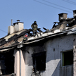 Ratownik sprawdza dach uszkodzonego budynku mieszkalnego po ataku rakietowym na Lwów, 15 sierpnia 20