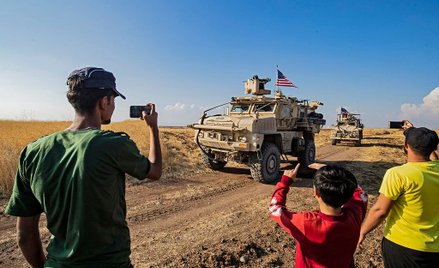Mieszkańcy Syrii fotografują amerykańskie pojazdy wojskowe, patrolujące tereny przy granicy syryjsko