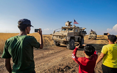 Mieszkańcy Syrii fotografują amerykańskie pojazdy wojskowe, patrolujące tereny przy granicy syryjsko
