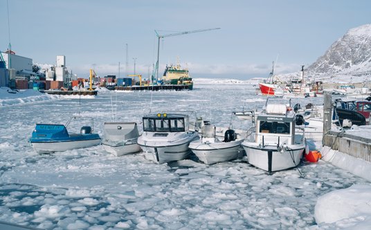 Małe łodzie rybackie zacumowane w morskim w porcie w Sisimiut