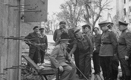 Premier Wielkiej Brytanii, sir Winston Churchill, siedzi na zniszczonym krześle w otoczeniu brytyjsk