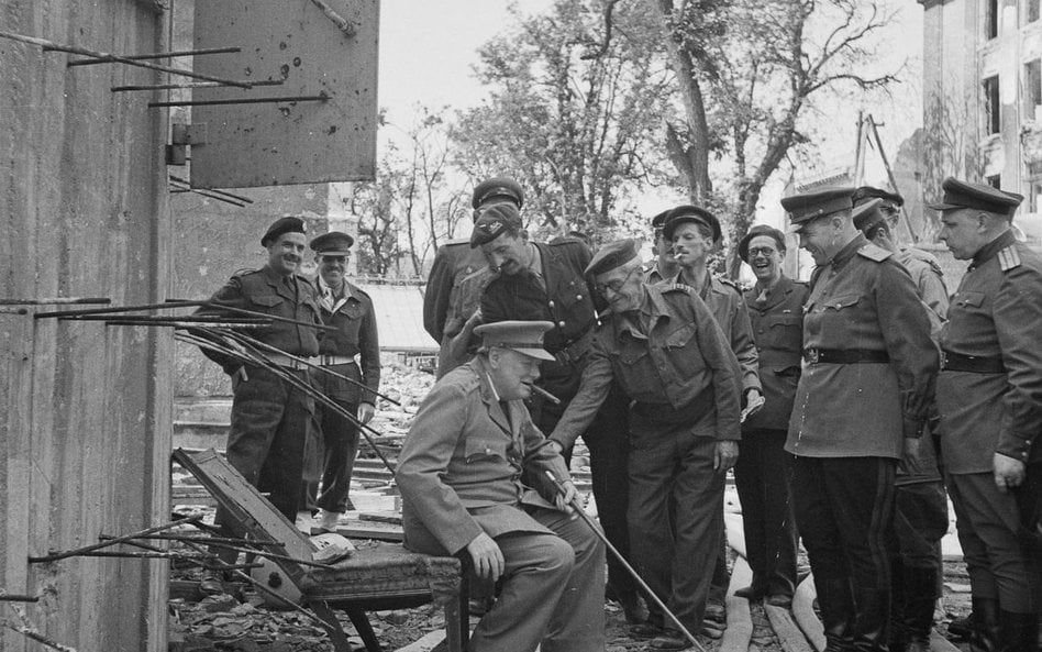 Premier Wielkiej Brytanii, sir Winston Churchill, siedzi na zniszczonym krześle w otoczeniu brytyjsk