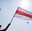 Mińsk, 7 czerwca. Zwolennik opozycji z flagą zdelegalizowaną przez Łukaszenkę w 1995 roku