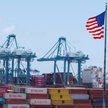 Amerykańska flaga powiewa nad statkiem i kontenerami transportowymi w porcie Los Angeles w San Pedro