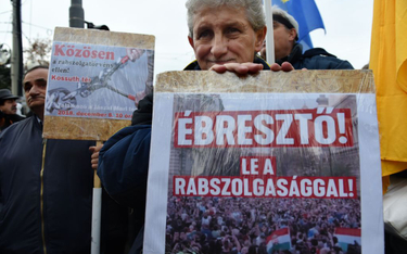 Protest w Budapeszcie. Jeden z demonstrantów z plakatem: Obudźcie się! Zatrzymajcie niewolnictwo