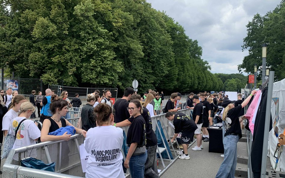 Tłum fanów przy stoiskach z pamiątkowymi koszulkami i bluzami