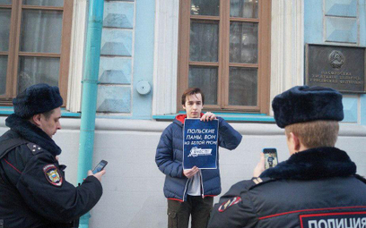 Protestujący pod ambasadą Białorusi w Moskwie trzyma plakat z napisem: "Polscy panowie, won z Białor