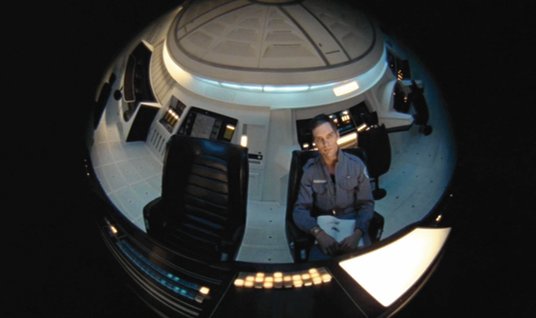 Astronauta David Bowman, którego zagrał Keir Dullea, w oku kamery komputera HAL 9000. Kadr z filmu „
