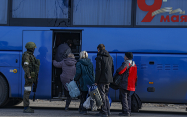 Rosyjscy żołnierze kontrolujący wsiadanie do autobusu cywilów ewakuowanych z Azowstalu w Mariupolu