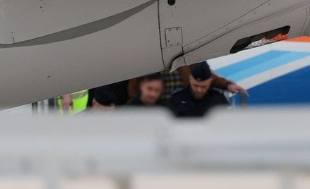 Sebastian M. opuszcza w asyście policji samolot po wylądowaniu na lotnisku Okęcie w Warszawie