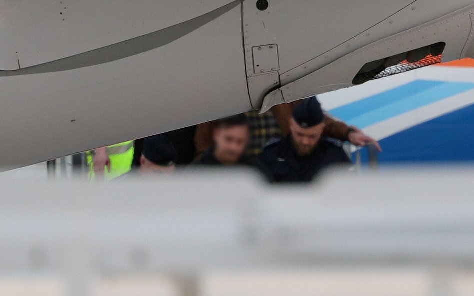 Sebastian M. opuszcza w asyście policji samolot po wylądowaniu na lotnisku Okęcie w Warszawie