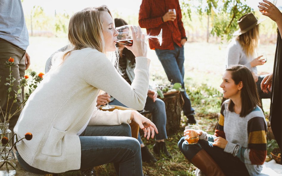 Osoby pijące wino z kieliszków na dworze