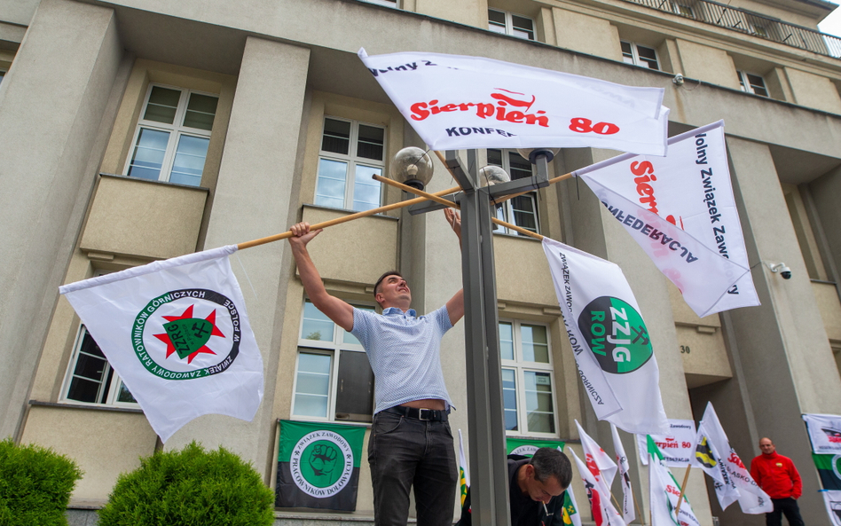 Flagi związkowe wywieszane przed siedzibą Polskiej Grupy Górniczej w Katowicach. Kilkudziesięciu zwi