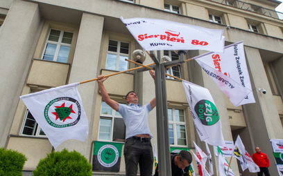 Flagi związkowe wywieszane przed siedzibą Polskiej Grupy Górniczej w Katowicach. Kilkudziesięciu zwi
