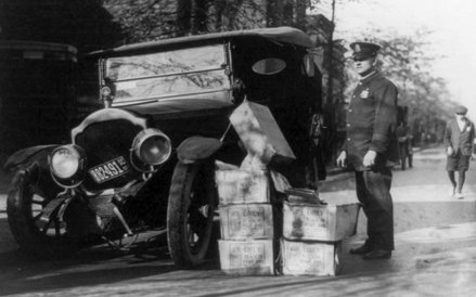 Samochody do przewozu bimbru gangsterzy nazywali moonshine runners. Policjant stoi obok rozbitego au