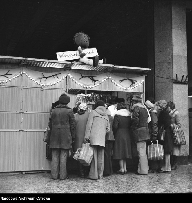 Sprzedaż ozdób choinkowych i zabawek na stoisku przed DH Smyk. Widoczni tłoczący się przy stoisku kl