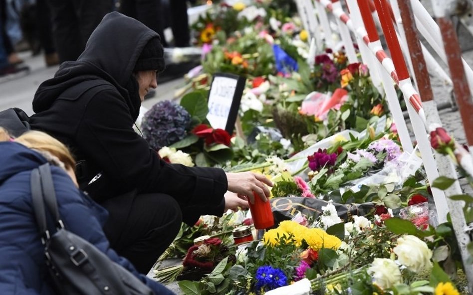 Na całym świecie ludzie spontanicznie składają kwiaty i zapalają znicze pod budynkami francuskich am