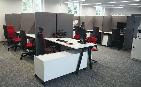 Biurka oddzielają ścianki działowe