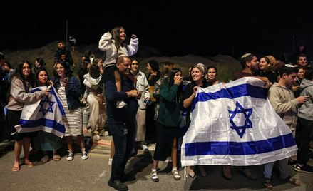 Mieszkańcy południowego Izraela wiwatujący na widok pojazdu przewożącego zakładników uwolnionych prz