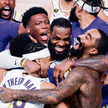 Gwiazdor Los Angeles Lakers LeBron James (w środku) świętuje z kolegami zwycięstwo w finale NBA