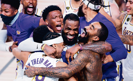 Gwiazdor Los Angeles Lakers LeBron James (w środku) świętuje z kolegami zwycięstwo w finale NBA