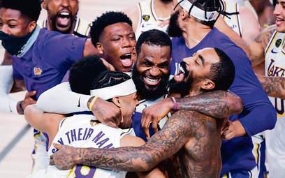 Gwiazdor Los Angeles Lakers LeBron James (w środku) świętuje z kolegami zwycięstwo w finale NBA