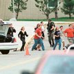 Students run from Columbine High School run under cover from police 20 April 1999 in Littleton, Colo