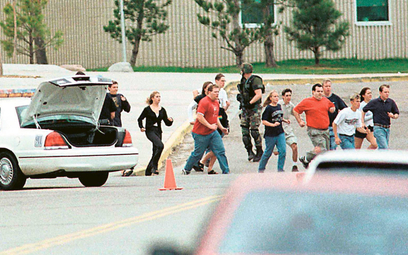 Students run from Columbine High School run under cover from police 20 April 1999 in Littleton, Colo