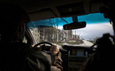 Ukraiński żołnierz jedzie przez Bachmut