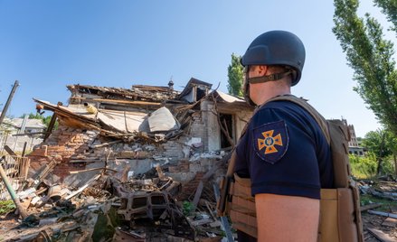 Ukraiński żołnierz przed guzami budynku w mieście Kupiańsk