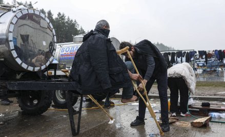 Imigranci w pobliżu przejścia granicznego w Bruzgach