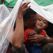 Filipińczyk, który ocalał z tajfunu, czeka z synem na ewakuację na lotnisku polowym Tacloban. Oni i 