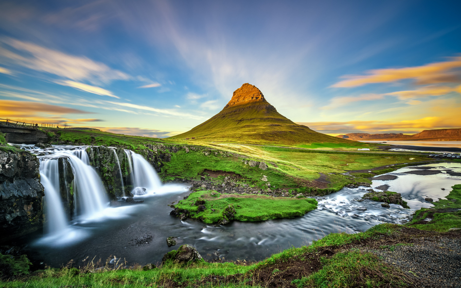 Zachód słońca nad wodospadem Kirkjufellsfoss i górą Kirkjufell w Islandii, która turystycznie ma wie