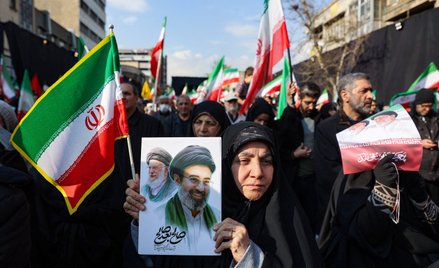 Proreżimowa demonstrantka w Iranie trzyma w ręku grafikę przedstawiającą na pierwszym planie Modżtab