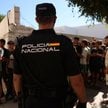 Policjant na warcie przed posterunkiem policji na Ceucie. W tle nieletni migranci czekają, by zareje