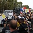 Papież Leon XIV macha do tłumu, jadąc papamobilem po Polach Elizejskich na mszę świętą