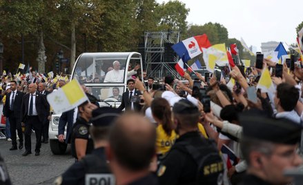 Papież Leon XIV macha do tłumu, jadąc papamobilem po Polach Elizejskich na mszę świętą