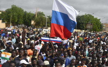 Protestujący trzymają rosyjską flagę podczas demonstracji w Niamey