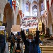 Grupa osób stanęła przed ołtarzem z transparentami o treściach związanych z prawem do aborcji; msza 