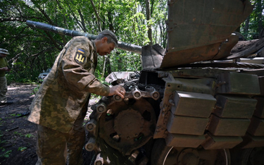 Ukraiński czołgista sprawdza czołg niedaleko linii frontu w obwodzie charkowskim, 6 lipca 2023 r.
