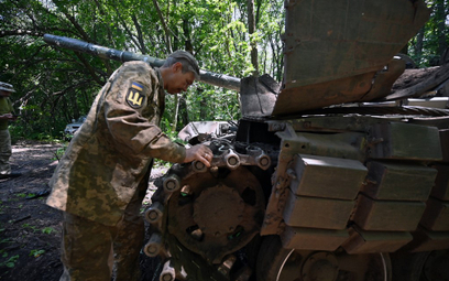 Ukraiński czołgista sprawdza czołg niedaleko linii frontu w obwodzie charkowskim, 6 lipca 2023 r.