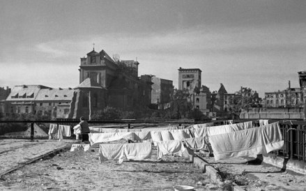 Warszawa 1946, fot. Jerzy Baranowski. Kobieta wywiesza pranie na sznurach rozci ą gni ę tych pomi ę 